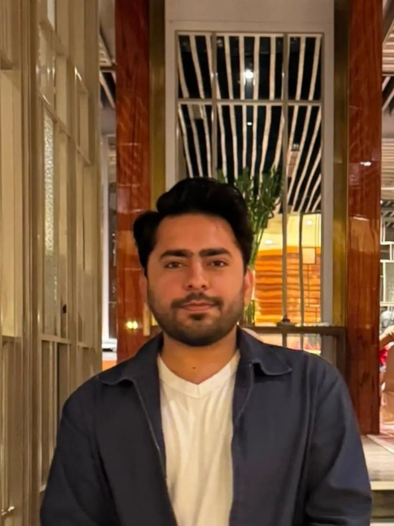 Adnan Ahsan, facing the camera, in a navy overshirt over a white t-shirt.